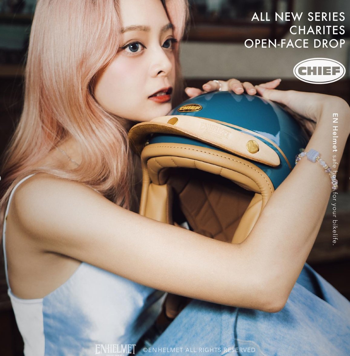 Campaign: model resting her chin on her hand, teal helmet on her knee