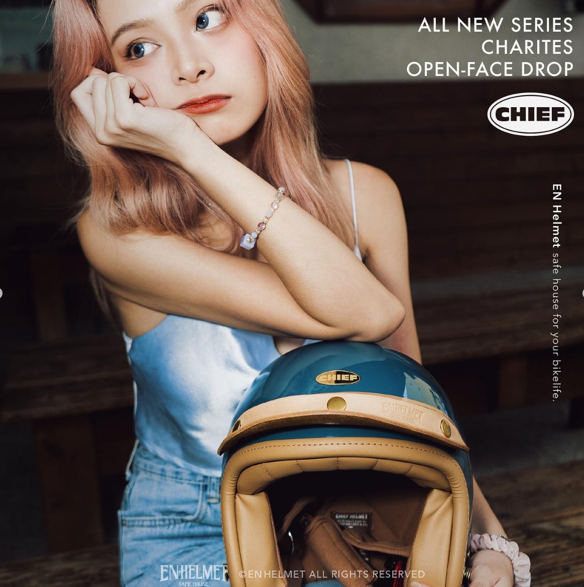 Campaign: model lifting a lilac open-face helmet beside a green bicycle